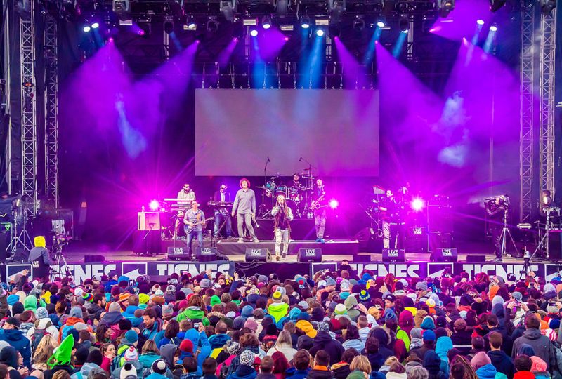 A big crowd watch a band perform on stage